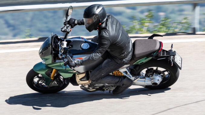 Kurvenfahrt einer grünen Moto Guzzi V100 Mandello, aufgenommen 2022.