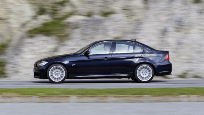 Ein blauer BMW E90 (07/2015) fährt an einem Berg vorbei.