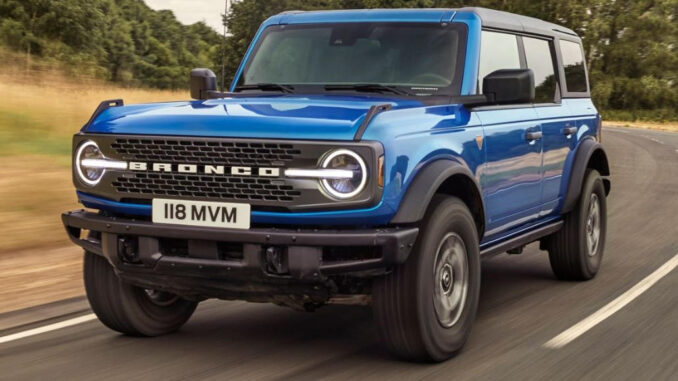 Ein blauer Ford Bronco fährt 2024 auf einer Landstarße.