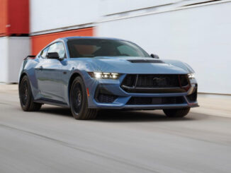 Ein blauer Ford Mustang fährt 2022 an Containern vorbei. Die Ford Motor Company hat die siebte Generation des berühmten Pony-Cars auf der North American International Auto Show (NAIAS) präsentiert. Die jüngste Auflage des meistverkauften Sportwagens der Welt geht erneut als Coupé und Cabriolet an den Start und wird voraussichtlich ab Spätsommer 2023 auch in Deutschland bestellbar sein.