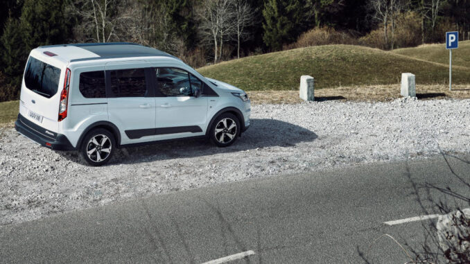 Ein weißer Ford Transit Connect steht 2019 auf dem Parkplatz einer Passstraße.