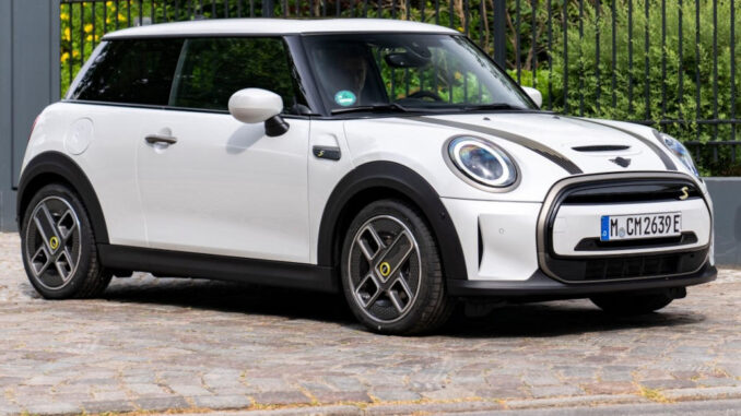 Ein weißer Mini Cooper SE steht 2023 vor einer Hamburger Villeneinfahrt.